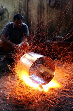 A man forging some iron metal for making brass in Tomang Village, Cepogo, Boyolali, Central Java, Indonesiaのeditorial素材