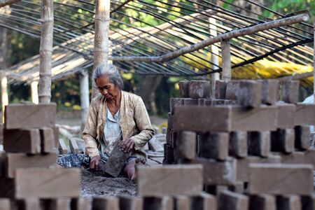 A woman makes red bricks in Karangwaluh village, Ponorogo, East Java, Indonesiaのeditorial素材
