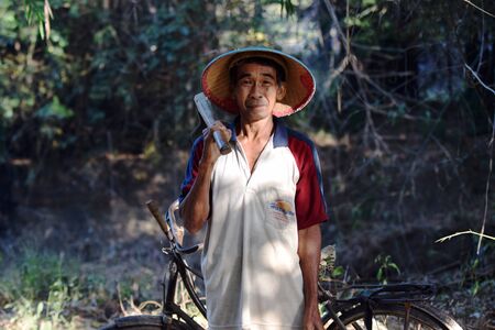 A man old farmer went to the fields in the village of Karangwaluh, Sampung, Ponorogo, East Java, Indonesiaのeditorial素材