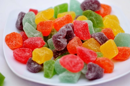 colorful jelly candies on plate isolated on whiteの写真素材
