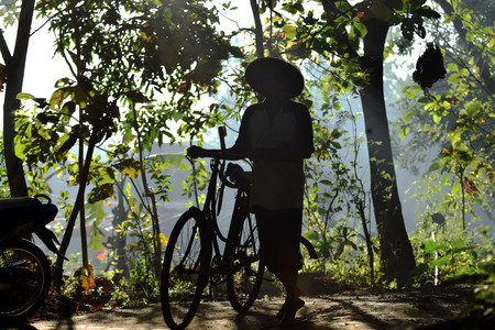 silhouettes, an old farmer man went to the fields in the village of Karang Waluh, Sampung, Ponorogo, East Java, Indonesiaの写真素材