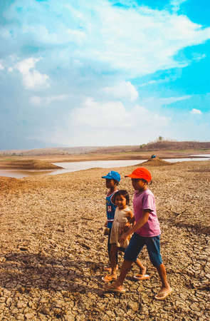 Groups of children play in a dry dam in Dawuhan Village, Madiun, East Java, Indonesia on August 28th, 2003. The long drought season in Indonesia this year has left thousands suffering from access to wのeditorial素材