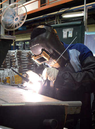 SIDOARJO, INDONESIA - APRIL 9, 2015: Workers welding on the assembly line at the bicycle assembly plant from Indonesia Polygon in Sidoarjo, East Java, Indonesia, Thursday, April 9, 2015.のeditorial素材