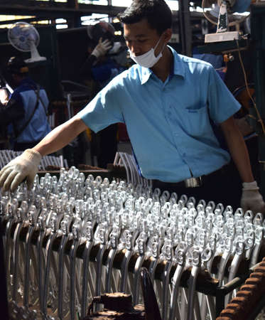 SIDOARJO, INDONESIA - APRIL 9, 2015: Workers check on the assembly line at the assembly bicycle bike...