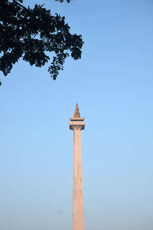 National Monument (Monas) in Jakarta, Indonesia with a clear sky backdrop at sunriseの写真素材