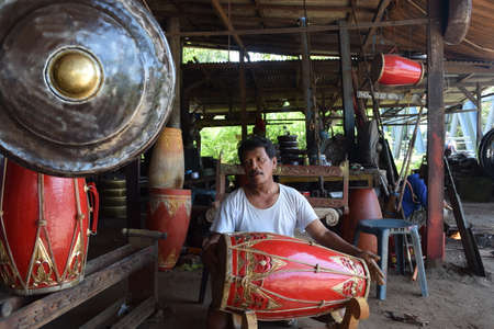 Ponorogo - Indonesia, May 15, 2015: A worker after completing gamelan playing drums in the...