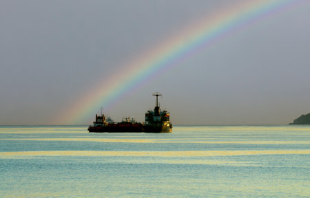 Bulk cargo ship under the rainbow in the sea, Thailand.の写真素材