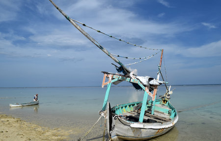 Traditional fishing boats with contrasting colors, boats anchored on a clean beach with calm sea