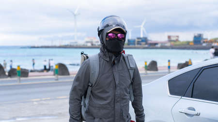 MERIDA, YUCATAN, MEXICO - MARCH 21, 2021: Young Caucasian tactical motorcycle police officer wears personal protective equipment and a black face mask and looks at the viewer, on March 21, 2021.のeditorial素材