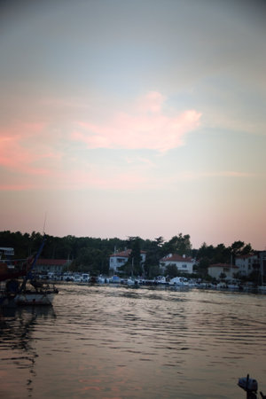 Vibrant sunset descending on the horizon, sea in golden colors, small waves gently touching the sands,の写真素材
