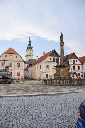 street scene in a small European town. The street is paved with cobblestones, and a central...