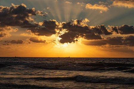 Beautiful sunset over the sea with rays of light passing through the cloudsの写真素材