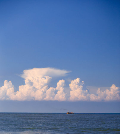 Fishing boat in the sea on blue sky with clouds background.の写真素材