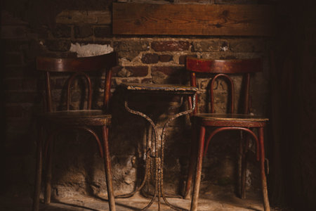 Old chairs and table in a room with brick walls. Selective focus.の写真素材