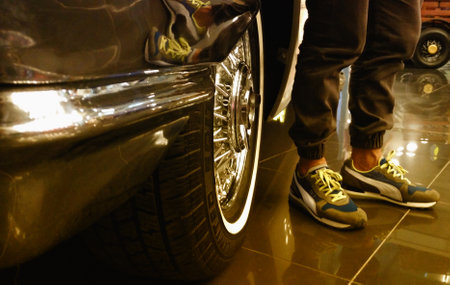 Tire image of classic car with shiny rims. Image of classic car tire and sneaker shoes