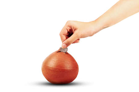 Hand putting money into a piggy bankの写真素材