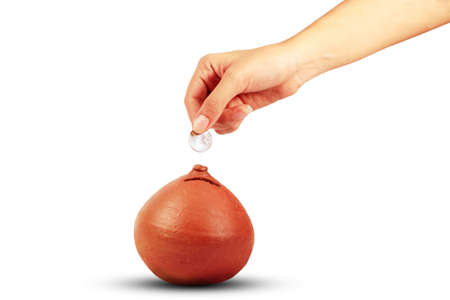 Hand putting money into a piggy bankの写真素材
