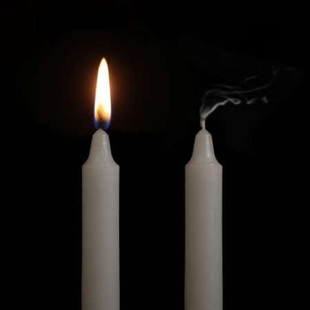 One candle is still lit while the other had just got blown outの写真素材