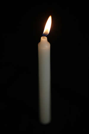 A single white candle against blackの写真素材