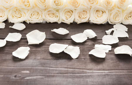 White roses are on the wooden background.の写真素材