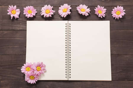 Pink flowers are on a notebook space for your text.の写真素材