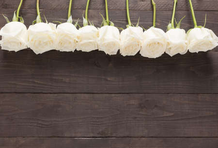 The arrangement of white roses flower are on the wooden background.の写真素材