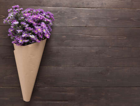 Purple cutter flower of bunch is on the wooden background.