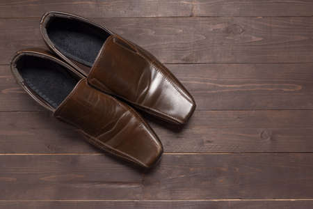 Leather shoes are on the wooden background.の写真素材
