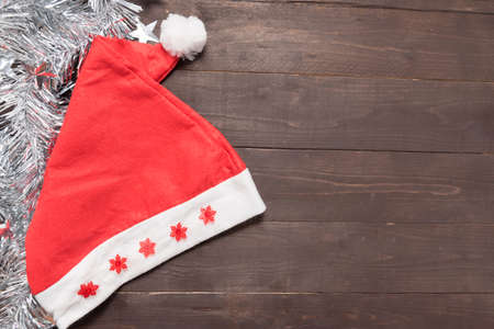 Red hat is on the wooden background with empty space for Christmas day.の写真素材