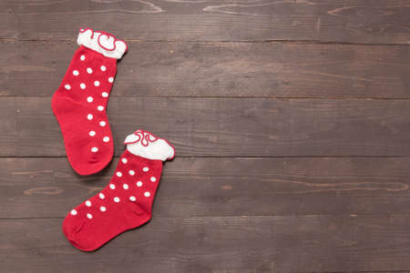 Red socks is on the wooden background with empty space for Christmas day.の写真素材