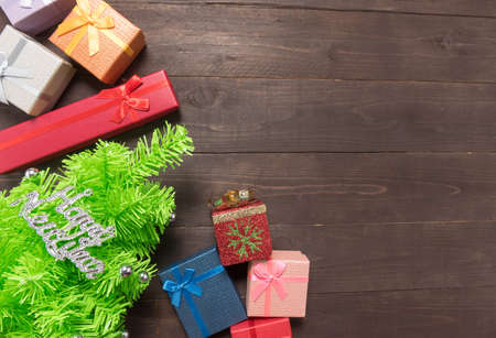 Gift boxes and Christmas tree on the wooden background with empty space.の写真素材