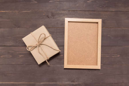 Gift box and picture frame are on the wooden background.の写真素材