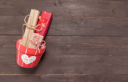 Gift boxes and flower pot are on the wooden background with empty space.の写真素材