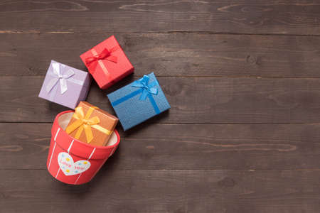 Gift boxes and flower pot are on the wooden background with empty space.の写真素材