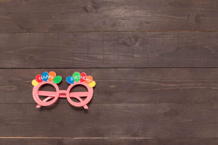 Pink glasses with Happy Birthday massage is on the wooden background. の写真素材