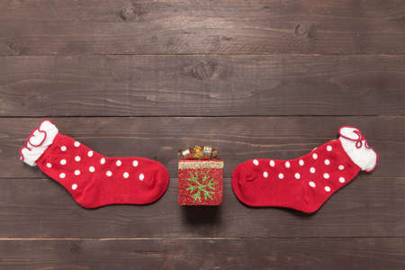 Red socks and gift are on the wooden background with empty space for Christmas day.の写真素材
