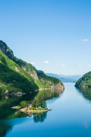 A small island with a wooden house in a fjord in Norway Eine kleine Insel mit Holzhaus in einem Fjord in Norwegenの写真素材