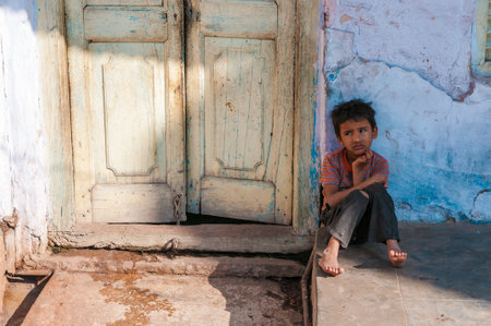 An Indian boy sits in front of a doorway, Pushkar, Rajasthan, Indiaのeditorial素材