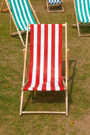 Canvas deckchairs on a grassy lawn in the summer.の写真素材