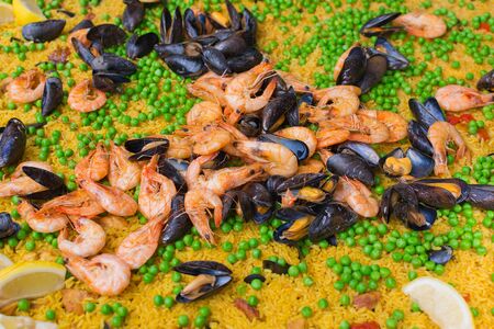 Close up of large pan of paella with mussels, prawns; rice and peas.の写真素材