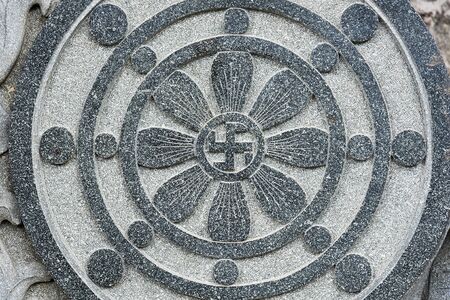 Stone carved radial design with Buddhist swastika symbol at the centre.の写真素材
