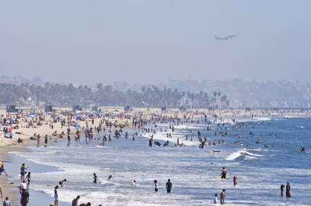 Jet flying over a crowded beach の写真素材