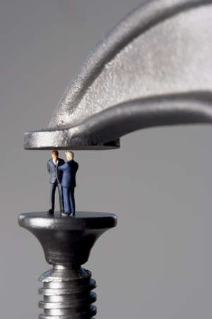 Business figurines in a clampの写真素材