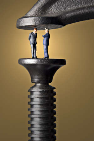 Business figurines in a clampの写真素材