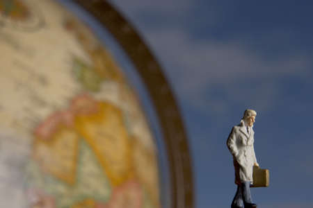 Business figurine placed next to globe.の写真素材