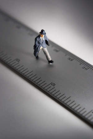 Business figure placed next to a rulerの写真素材
