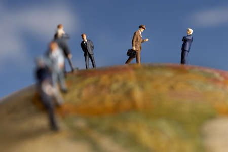 Business figurine placed on antique earth globe.の写真素材