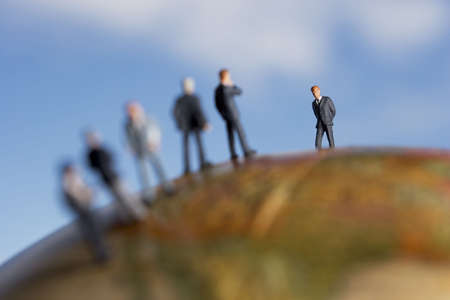 Business figurine placed on antique earth globe.の写真素材