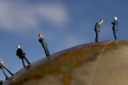 Business figurine placed on antique earth globe.の写真素材