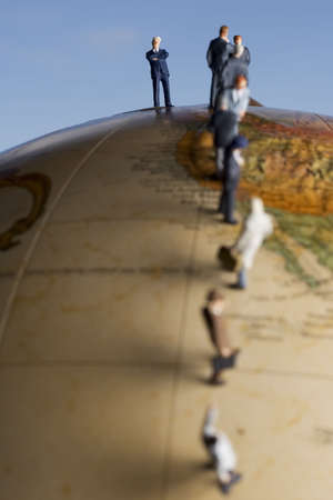 Business figurine placed on antique earth globe.の写真素材